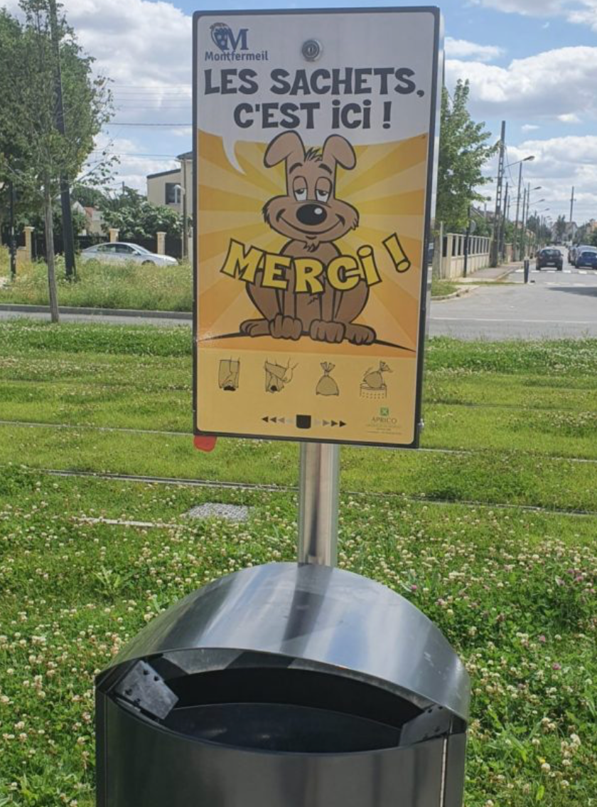 A sign urging French people to use the bags to scoop up dog poop. The sign says, the sachets are here