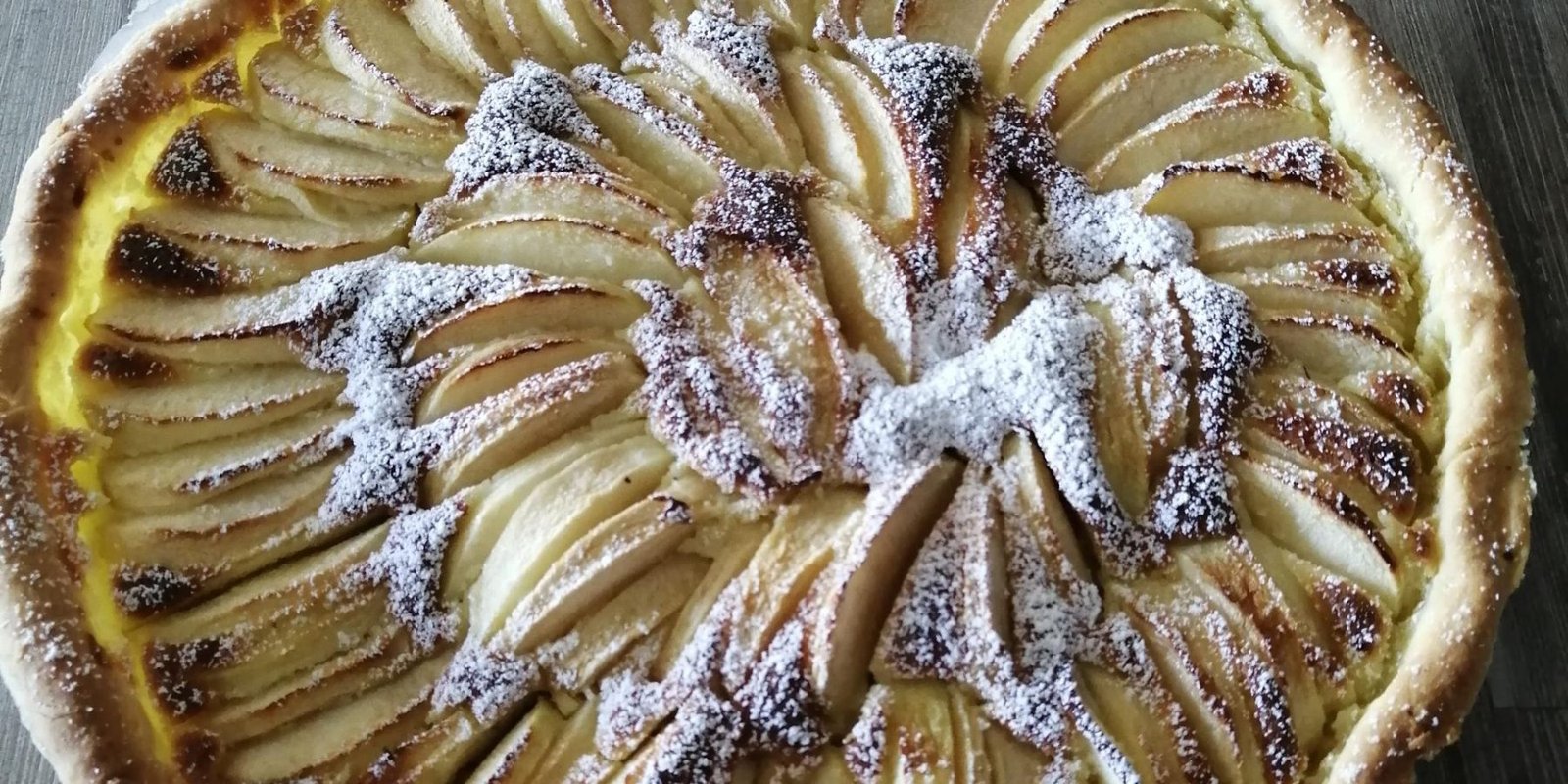 A tarte aux pommes normandes, Normand apple tart, with slices of apple in a circular pattern arranged in the pastry