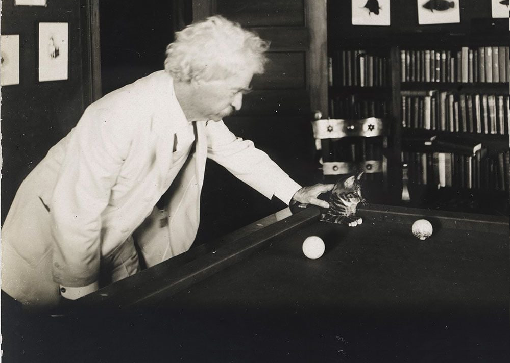 Mark Twain pats a puss on a billiard table