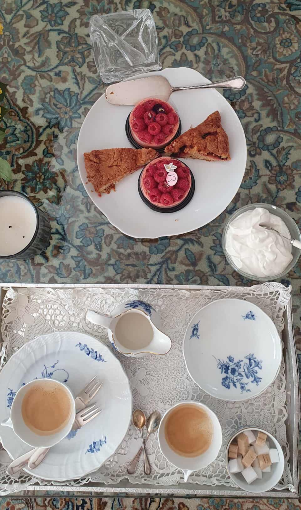 An arrange of deserts on plates with coffee cups ready for an afternooon tea of sweet Strasbourg pastty treats